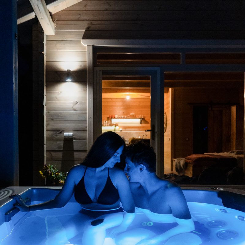 Boldog pár pihen este a Chalet jakuzzijában, felnőttbarát, felnőttbarát szálláshely