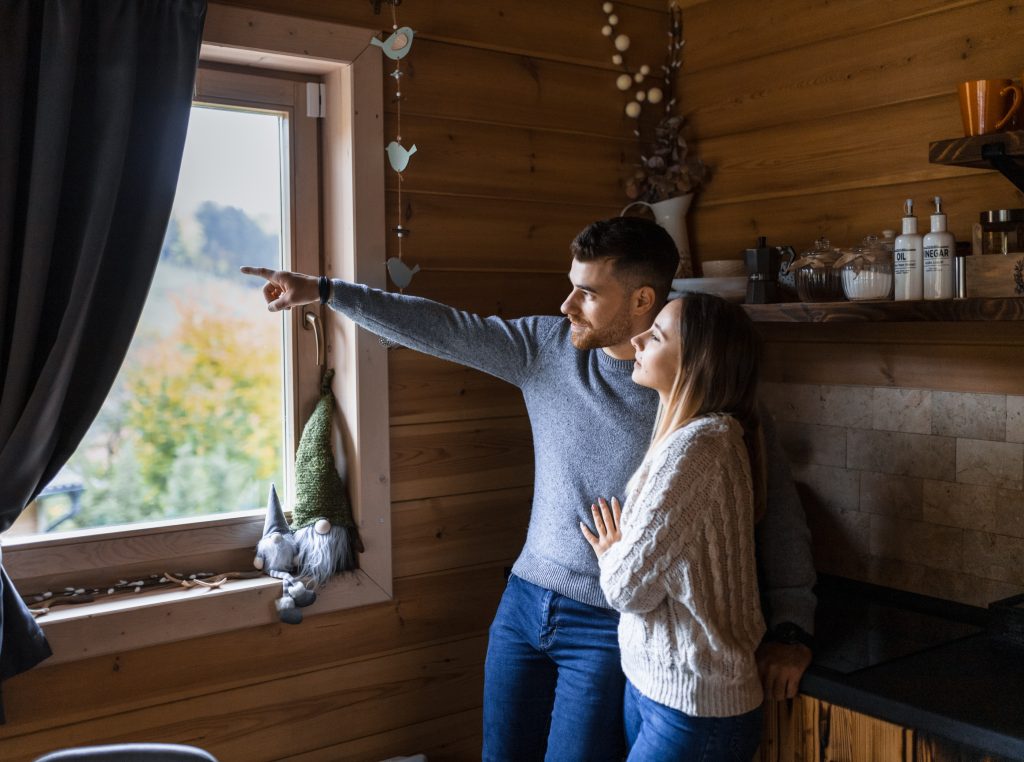 Egy pár gyönyörködik a bükki tájban a Chalet gerendaház ablakából