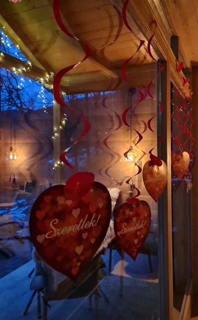 Romantikus vörös szíves dekorációk függnek a Chalet bejáratánál