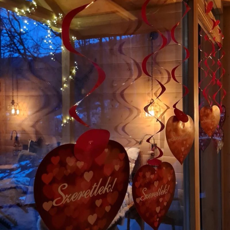 Romantikus vörös szíves dekorációk függnek a Chalet bejáratánál