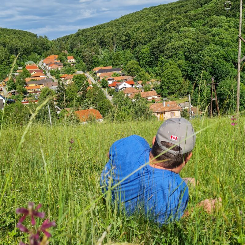 A Chalet férfi vendége a magas fűben fekszik a mezőn és csodálja Répáshuta gyönyörű panorámáját